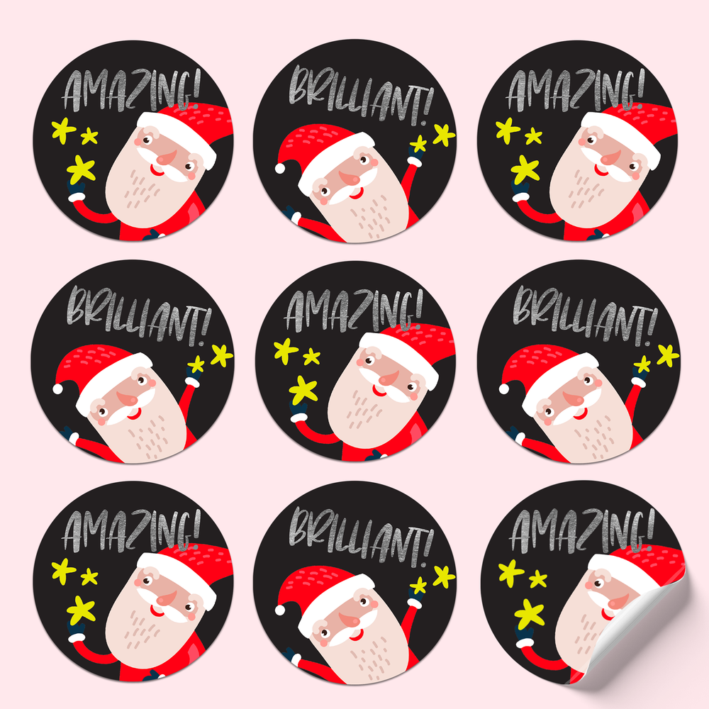 Sticker sheet featuring Santa in two poses, with gold star sparkles on a black background and silver foil text saying 'Amazing!' and 'Brilliant!'