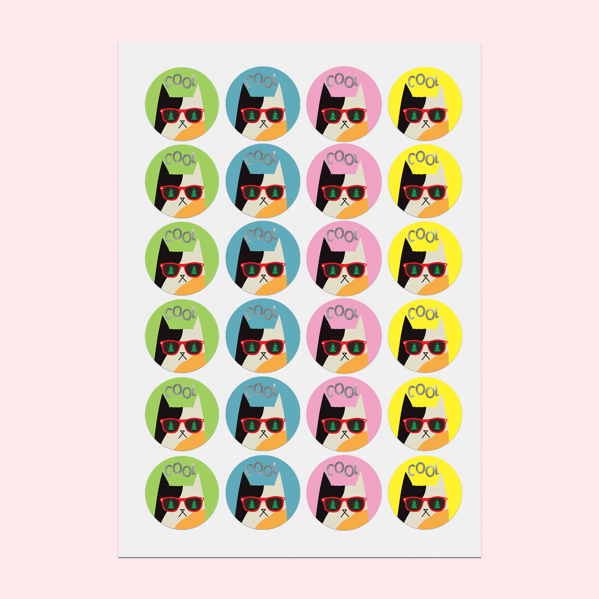Full A5 sticker sheet on a desk featuring a calico cat in Christmas sunglasses on colourful backgrounds, with silver foiled text reading 'Cool.'