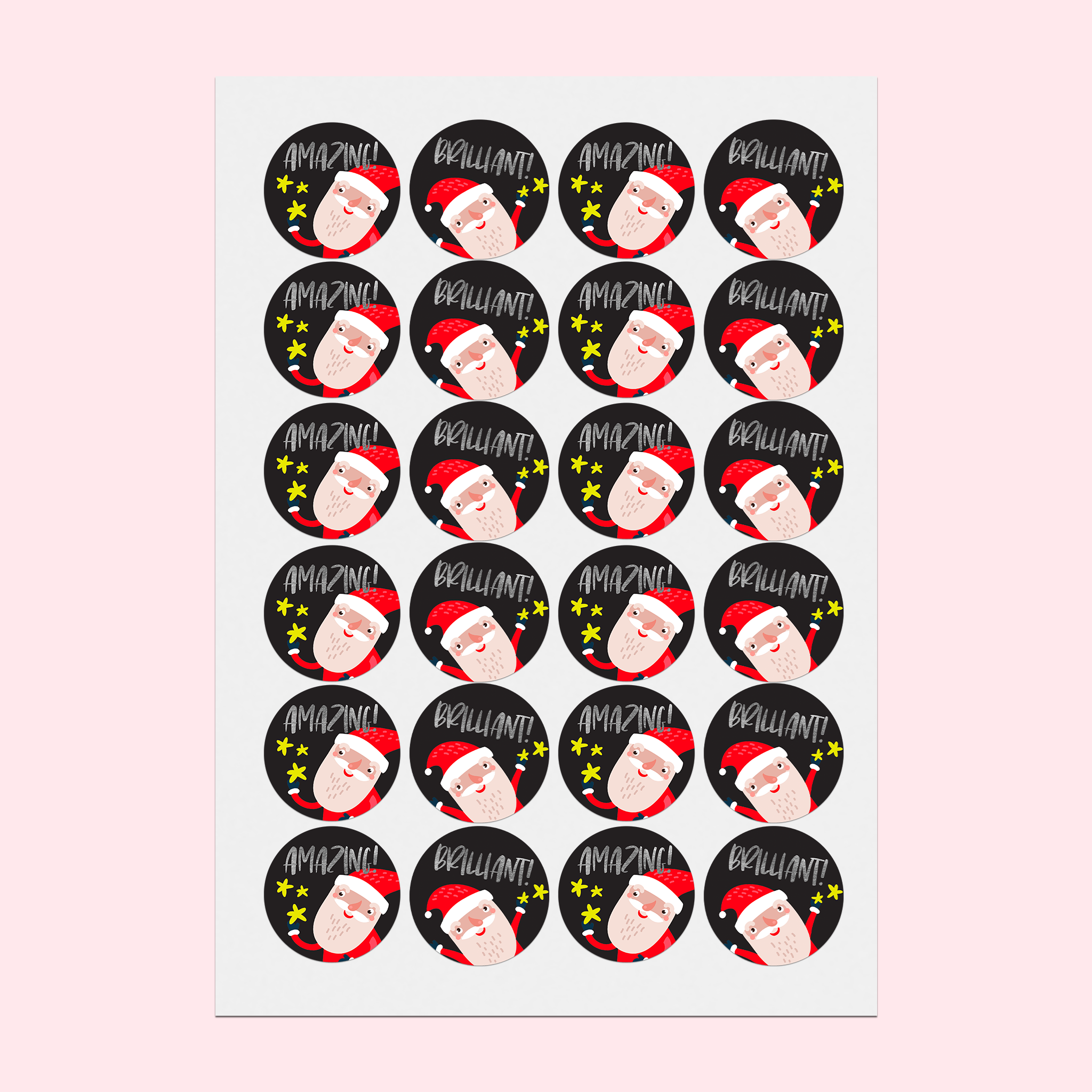 Zoomed-out shot of the A5 sticker sheet featuring Santa in two poses, with gold star sparkles and silver foil text 'Amazing!' and 'Brilliant!', lying on a desk.